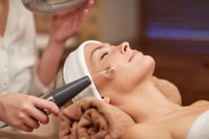 close up of young woman having face massage in spa